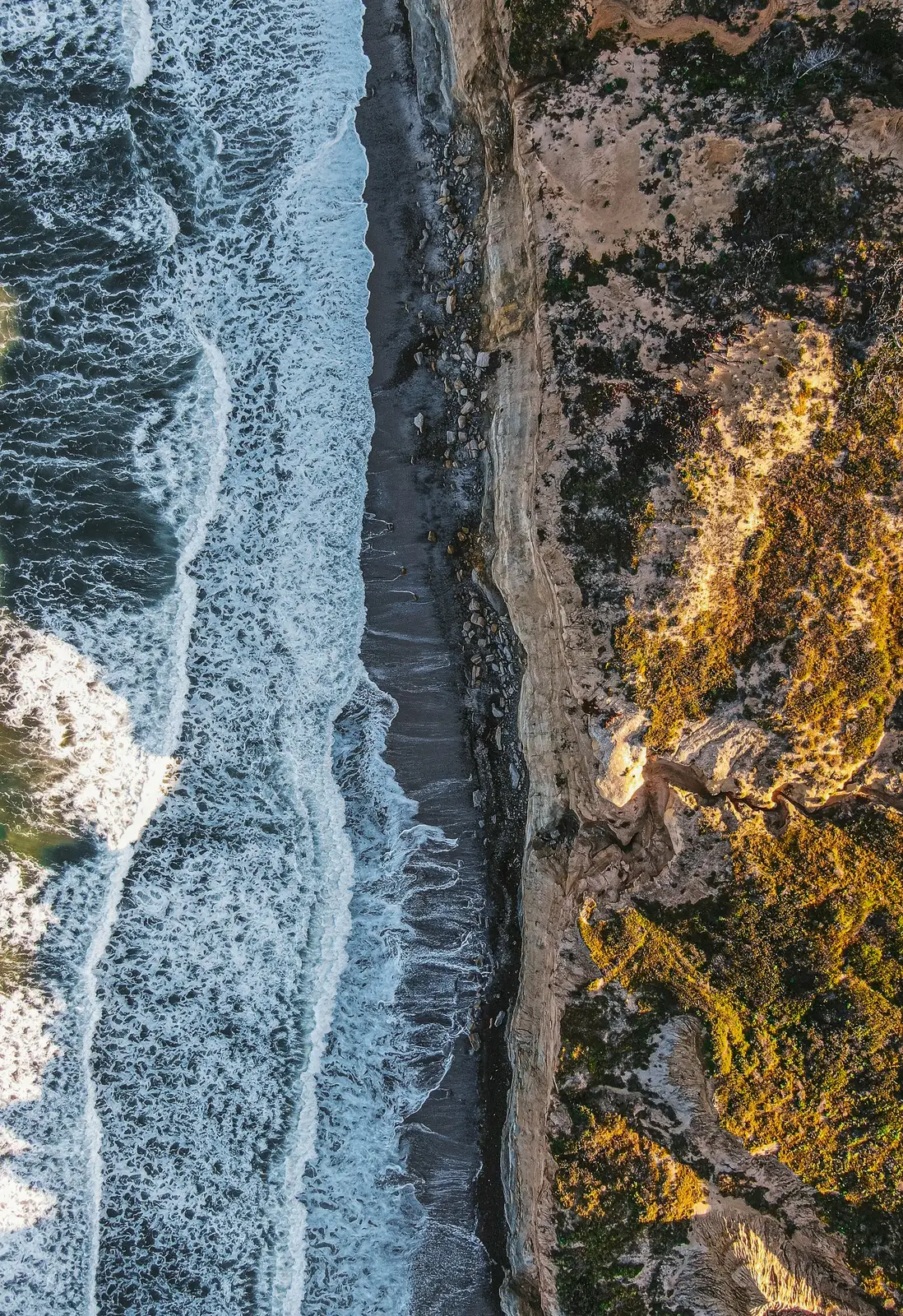 Aerial view of Pacific water meeting the sandstone coast at Torrey Pines